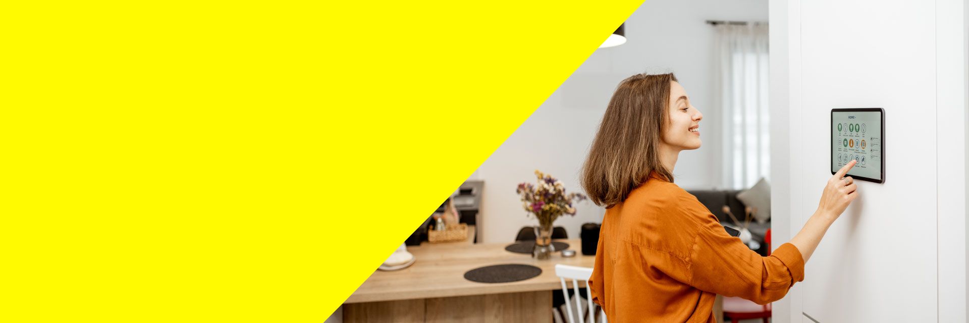 Frau bedient ihre Smarthome-Steuerung, um damit das Licht in ihrer Wohnung zu dimmen.